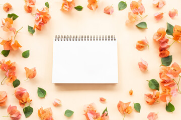 open blank notepad with orange bougainvillea flowers