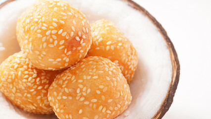 Thai dessert sesame balls stuffed with fried mung beans in a coconut shell