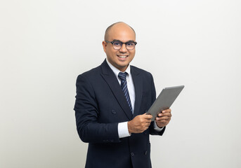 Portrait of Young asian businessman using digital tablet on isolated white background. Handsome middle aged Indian businessman holding tablet computer in office uniform.