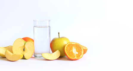 Tall glass with clean water and fruits on a light background, empty space for text. Healthy food concept