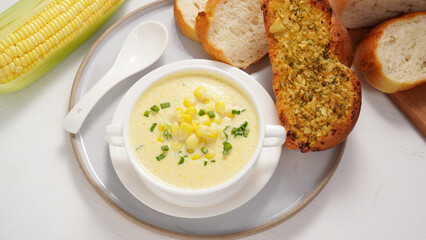 Corn Soup and Bread breakfast menu on white table