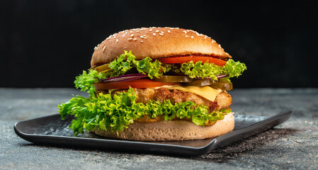 fresh homemade burger with beef, tomato, cheese, and lettuce. fast food and junk food concept