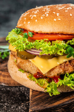 burger with double cutlet on a wooden board, Hamburger. Fast food concept. vertical image. place for text