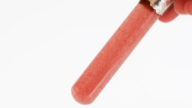 Haematococcus pluvialis in test tube with clear liquid. Astaxanthin, protection of UV-radiation, antioxidant. Abstract body care cosmetics