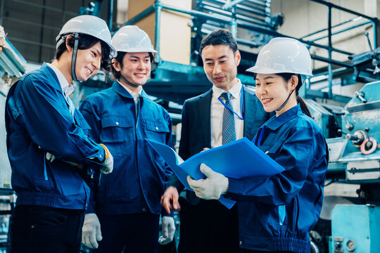 工場で資料を確認する労働者