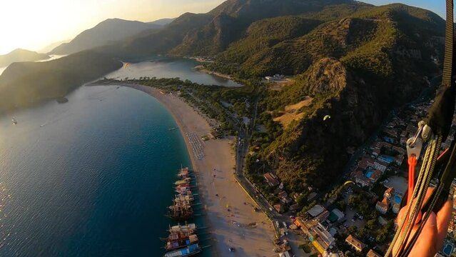 paragliding point of view in Oludeniz. paraglider flying over the sea and the beach on sunset. Extreme and active types of recreation. panoramic view from gopro. High quality FullHD footage