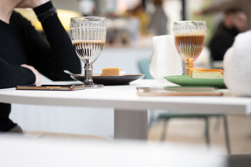 Glasses with coffee latte in a street cafe. View of the street cafe table. Friends having coffee togethe