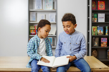 Two African American children are reading book, studying at school and having fun. Back to school.