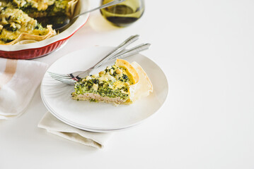 Quiche. Healthy homemade chicken pie with broccoli and spinach on white wooden table