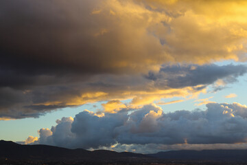 Dramatic Sky with Grey Clouds and Orange Sky around Sunset Time about to Rain With A Silhouette of Mountain