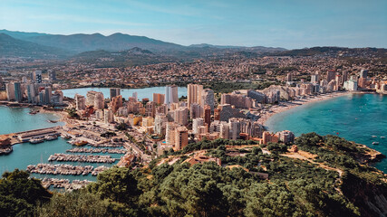 Fototapeta na wymiar Panorama of the city of Calpe, province of Alicante, seen from the Penon de Ifach. Summer holidays in Costa Blanca. Beaches and port with boats and yachts. Travel, hiking, sea vacation concept
