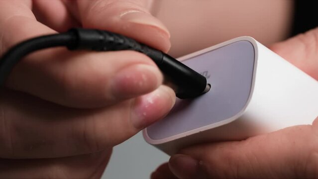 fast charging for smartphone, connecting a cable to a power supply with a type-c socket on white background, close-up