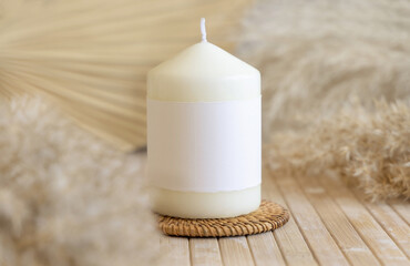 Candle with label on white table with dried pampas grass, Close up, copy space. Packaging mock up