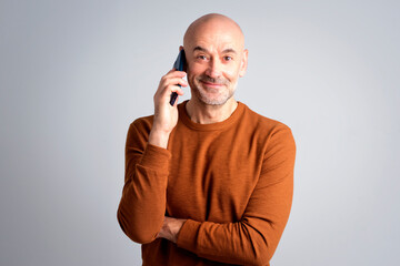 Portrait of a confident mature man with smartphone against isolated background - 594278904