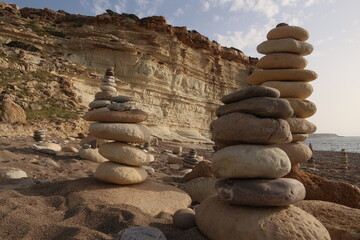 Fototapeta na wymiar Stone towers stacked with stones on a Cypriot beach