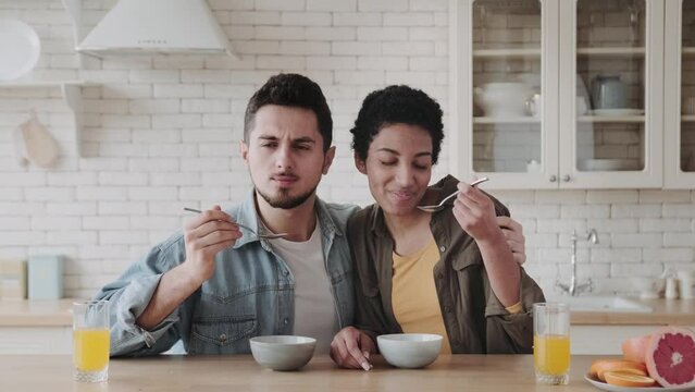 a young married couple in the kitchen eats healthy porridge of starlets in a bright kitchen