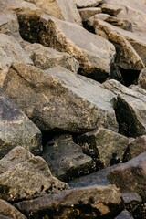 Fototapeta na wymiar Vertical shot of massive rocks on the beach, perfect for wallpapers