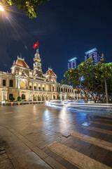 Naklejka premium Traffic in front of Ho Chi Minh City Hall, Saigon City Hall or Committee Head office in the evening, Vietnam. Light trail and night. Popular place to visit in Saigon. Travel destinations in Vietnam