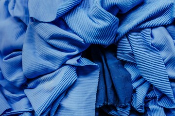 a group of folded clothes with multiple folds, in blue