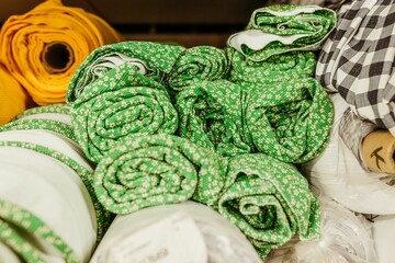 rolls of different colored fabrics on top of each other