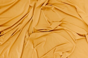 Pristine yellow cotton blanket neatly tucked in atop a plush bed