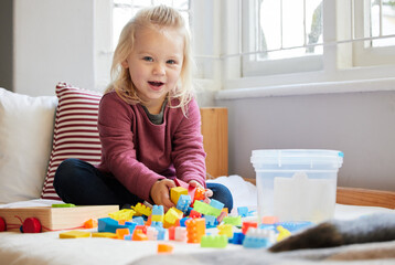 Being creative with blocks. a little girl playing at home.