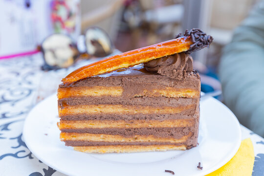A decadent, layered Dobos Torte with dark chocolate icing at restaurant, caramel glaze is the perfect addition to any celebration.