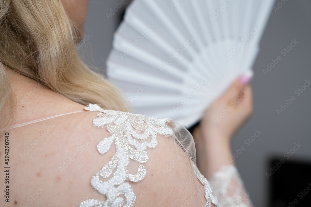 Wall mural bride in white dress holding a white bride hand fan