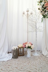 Vertical shot of flower bouquets with white curtains. Wedding floral decoration.