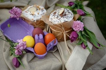 Fototapeta na wymiar Traditional Ukrainian Easter cake with white meringue.spring flowers and colorful painted eggs. Traditional Kulich, Paska Easter Bread. postcard. happy easter
