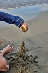 MAKING A CASTLE WITH SEA SAND