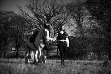 Fototapeta na wymiar Grayscale shot of a young girl with a horse