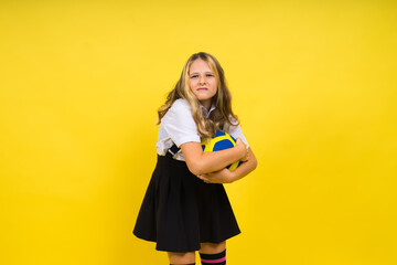 Portrait of a cute eight year old girl in volleyball outfit isolated on red yellow background