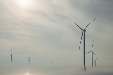 Windmills with rotor blades producing renewable clean energy in countryside. Windmills turbines...