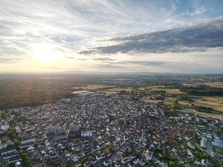 Aerial view of a city located in an open field with the sun about the set on the horizon