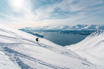 Ski alpinist skiing down the mountain Lyngen Alps, Norway 