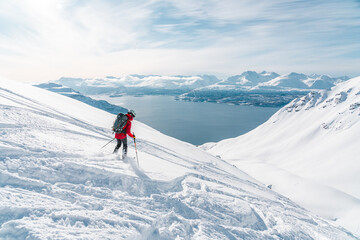 Ski alpinist skiing down the mountain Lyngen Alps, Norway 