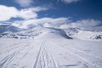 Fototapeta na wymiar Idyllic cross-country ski trail set against a majestic backdrop of snow-capped mountains.