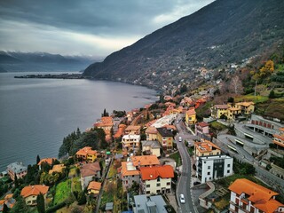 Drone view of Lake Como surrounded by a town and mountains in the evening in Italy