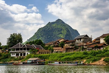 Obraz premium many boats and houses sitting along the river shore near mountains