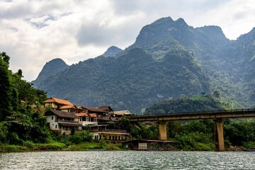 the town and mountains are shown from across the water of the river