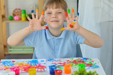 Boy paint fingers drawing baby painting hand therapy children art play. Kids have fun and create picture. Palms of different colors. Sensory development and experiences