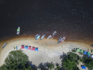 a small beach with boats lined up and water in the distance