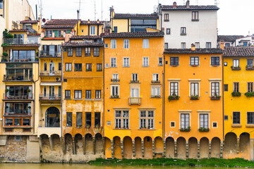 Fototapeta na wymiar Beautiful architecture of Firenze, Tuscany, Italy, beautiful yellow colors above the water of Arno river