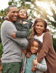 Were one happy family. a young family standing outside together and posing in their garden.