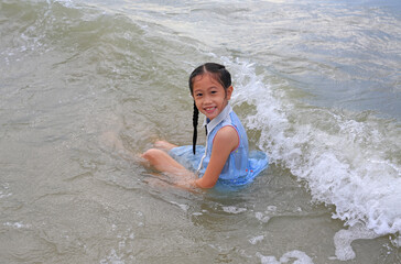 Asian young girl enjoy playing and lying on tropical sea beach.