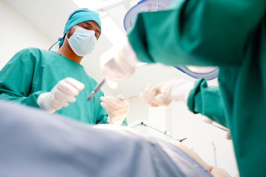 Team of doctors and patients in the operating room medical concept.