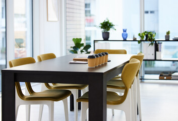 Lets get brainstorming. coffee and paperwork on a desk in an empty office during the day.