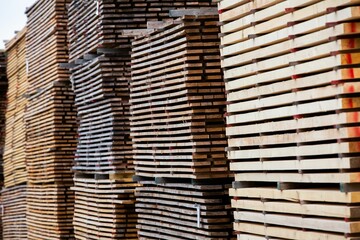 Stacked wooden planks in a warehouse. Carpentry material.