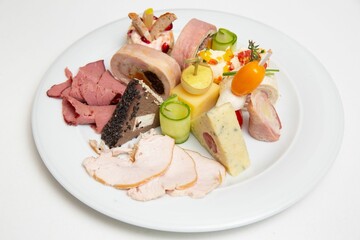 Closeup of a plate with different types of cheese and ham.